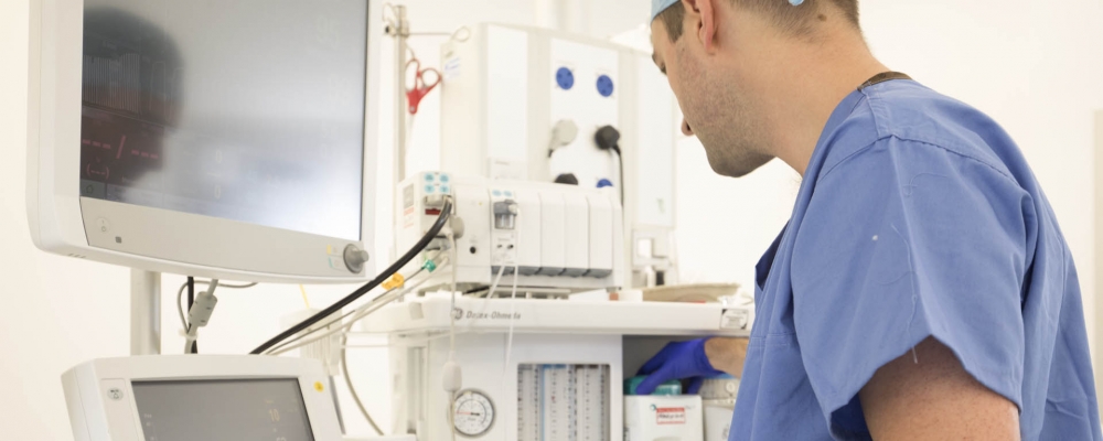 Anaesthetist reviewing machinery